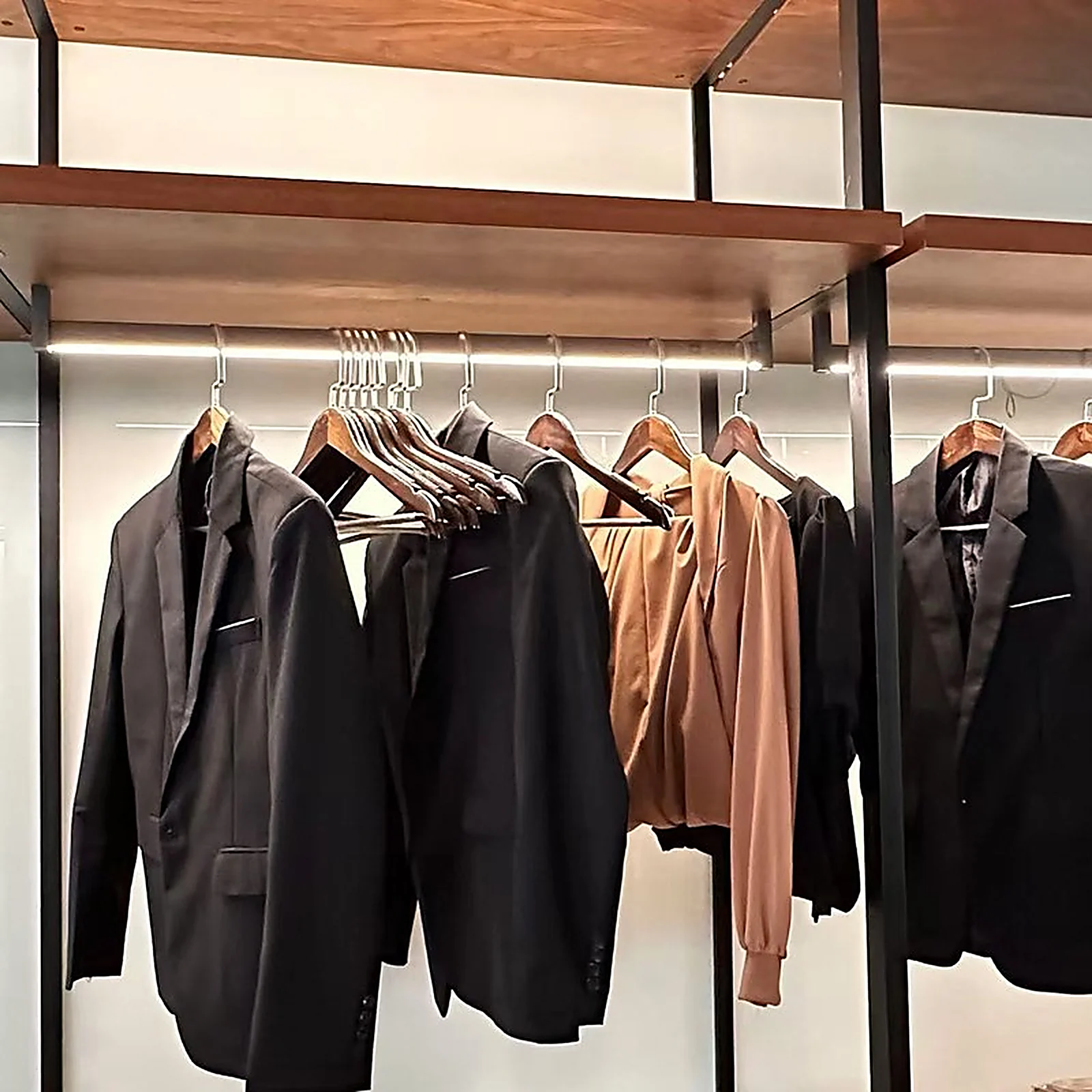 Lysstang wardrobe hanger LED profile lighting a row of garments in an open wardrobe